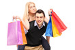 A young man giving a piggyback ride to a woman with shopping bag