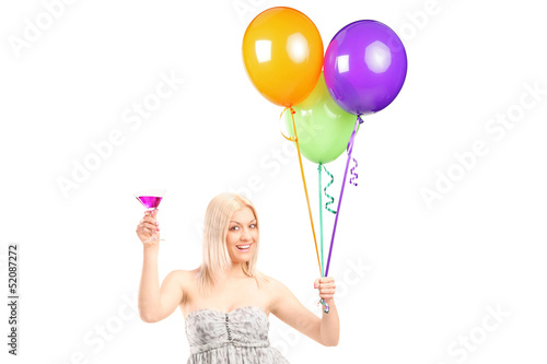 Photo: A pretty blond female holding balloons and cocktail A pretty blond female holding balloons and cocktail