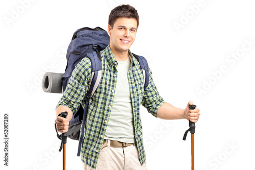Photo: A smiling hiker with backpack and hiking poles posing A smiling hiker with backpack and hiking poles posing