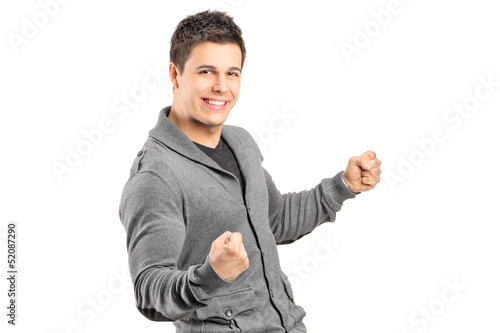 Photo: A young male gesturing happiness ands looking at camera A young male gesturing happiness ands looking at camera