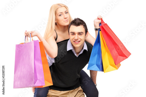 Photo: A young man giving a piggyback ride to a woman with shopping bag A young man giving a piggyback ride to a woman with shopping bag