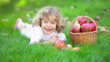 Happy child with red apples in autumn park