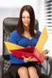 young businesswoman with folders sitting in chair