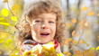 Happy child playing outdoors in autumn park
