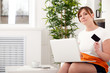 Photo: Closeup portrait of woman with a laptop and card Closeup portrait of woman with a laptop and card