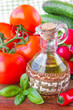 The branch of fresh tomatoes, cucumbers, radishes and a bottle o