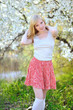 Beautiful girl posing in blooming tree on nature