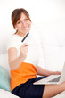 Foto: woman with card in hand and laptop woman with card in hand and laptop