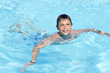 Activities on the pool. Cute boy swimming and playing in water i