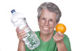 Dame âgée avec une bouteille d'eau et une orange