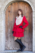 Photo: young beautiful redhaired woman in front of the old door young beautiful redhaired woman in front of the old door