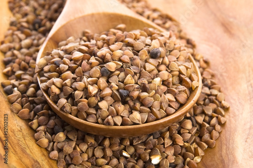 Photo: Buckwheat seeds on wooden spoon in closeup Buckwheat seeds on wooden spoon in closeup