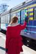 Photo: woman in red waving hand on the platform woman in red waving hand on the platform