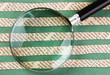 Foto: Collage cut from newspaper and magnifying glass on green backgr Collage cut from newspaper and magnifying glass on green backgr