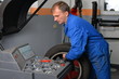 Foto: Wheel Balancing, Auto mechanic spins a car wheel Wheel Balancing, Auto mechanic spins a car wheel