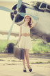 Lonely girl with suitcase at near airplane.