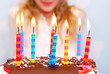 Foto: young girl celebrates birthday and blowing candles on the cake young girl celebrates birthday and blowing candles on the cake