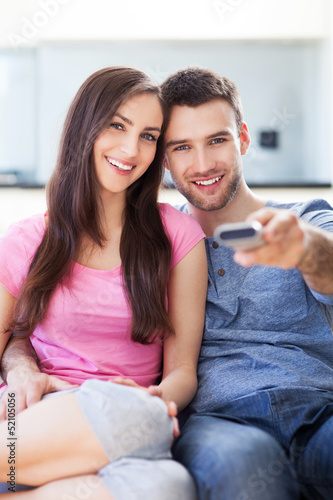 Photo: Young couple with TV remote Young couple with TV remote