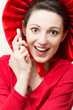 Young happy surprised woman with mobile phone wearing red dress
