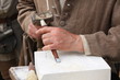 old craftsman Mason during the processing of a piece of white ma
