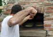 muscled Baker when baking bread in a wood-burning oven
