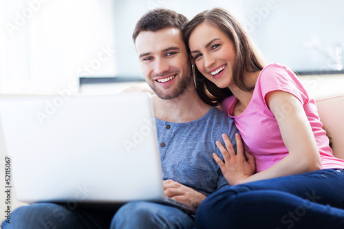 Photo: Couple on sofa with laptop Couple on sofa with laptop