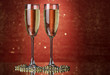 Two glasses of champagne on bright background with lights