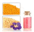 Colorful beads heap in boxes and glass bottle isolated on white