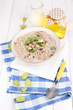 Useful oatmeal in bowl with fruit on wooden table close-up