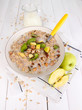 Useful oatmeal in bowl with fruit on wooden table close-up