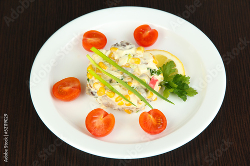 Photo: Small portion of food on big plate on wooden table Small portion of food on big plate on wooden table
