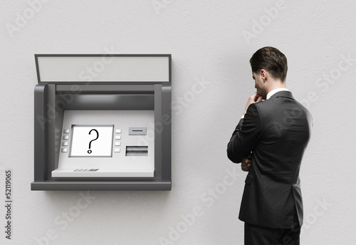 Photo: man looking at atm man looking at atm