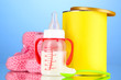 Bottle with milk and food for babies on blue background