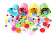 Colorful buttons strewn from buckets isolated on white