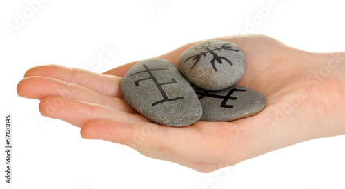 Photo: Fortune telling with symbols on stone in hand isolated on Fortune telling with symbols on stone in hand isolated on