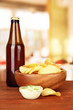 Potato chips and glass bottle with beverage,