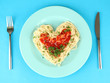 Cooked spaghetti carefully arranged in  heart shape and topped