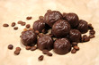 Chocolate candies and coffee beans, on beige paper background
