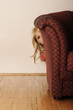 Girl hiding behind sofa