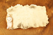 Old paper with figurine, on wooden background