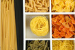Different types of pasta in white wooden box sections close-up
