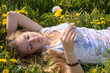 Spring: young woman sleeping between dandelion flowers