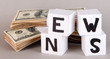 White paper cubes labeled "News" with money on grey background