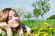 Young woman enjoying the spring between dandelions