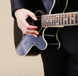 Closeup of a man in suit  playing an acoustic guitar