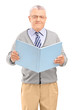 A middle aged gentleman holding a book and looking at camera