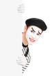 A smiling mime artist posing behind a blank panel