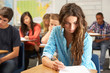 Female Pupil Studying At Desk In Classroom