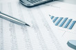 Business data report print, smartphone and pen. Blue toned.