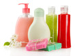 Cosmetics bottles and natural handmade soap on green background